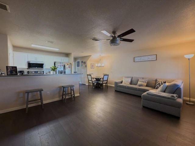 5828 Giddyup Ln, Fort Worth, TX 76179 - living area with visible vents, a ceiling fan, dark wood-style flooring, and a textured ceiling