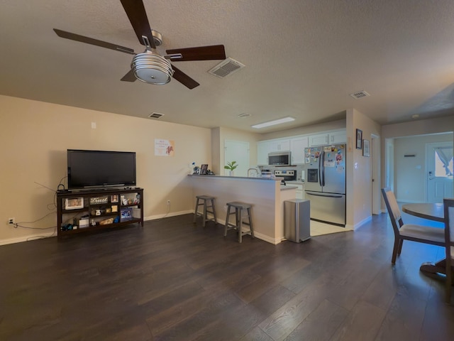 5828 Giddyup Ln, Fort Worth, TX 76179 - kitchen featuring visible vents, a peninsula, wood finished floors, stainless steel appliances, and a ceiling fan