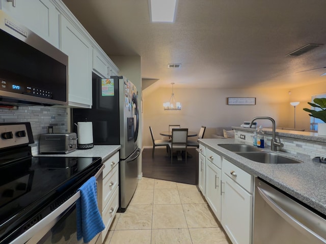 5828 Giddyup Ln, Fort Worth, TX 76179 - kitchen with visible vents, a sink, tasteful backsplash, stainless steel appliances, and a chandelier