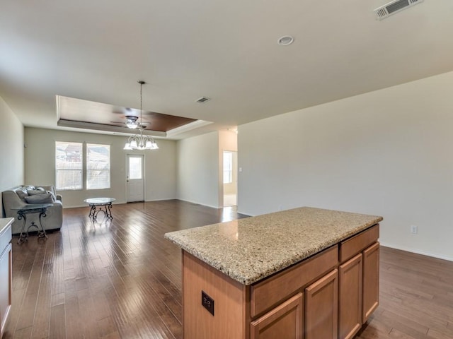 2232 Heaton St, Forney, TX 75126 - kitchen with open floor plan, a raised ceiling, dark wood-style floors, ceiling fan, and a kitchen island