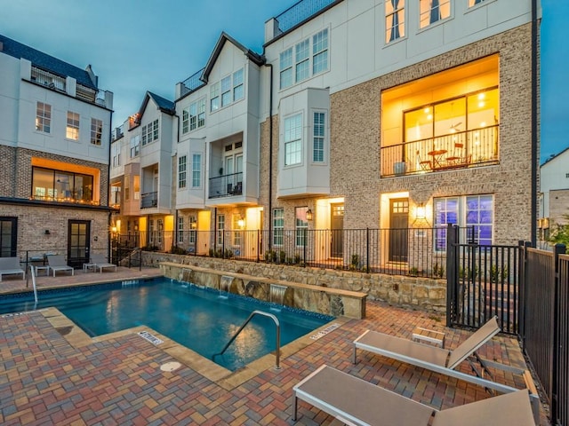 pool with a patio and fence