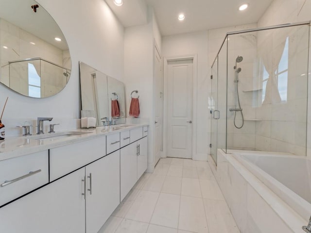 bathroom with a shower stall, a tub, double vanity, tile patterned floors, and a sink