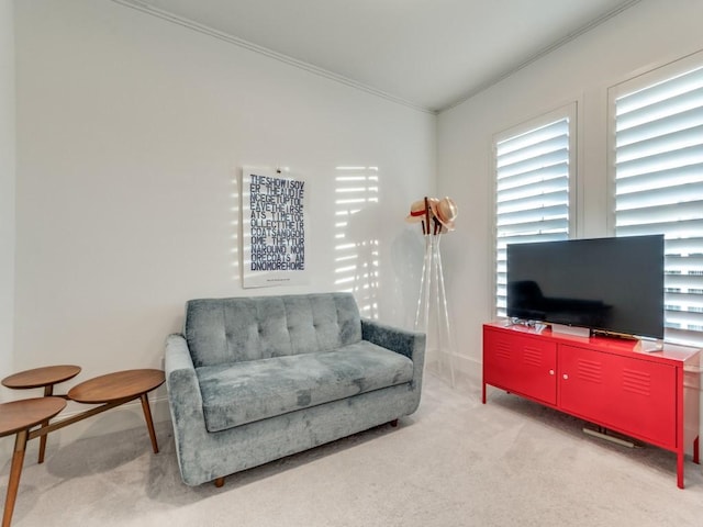 sitting room with carpet flooring, crown molding, and baseboards