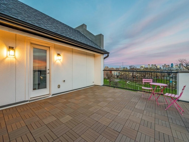 patio terrace at dusk featuring a city view