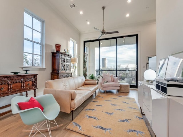 living area featuring visible vents, ceiling fan, ornamental molding, recessed lighting, and wood finished floors