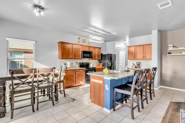 1380 Levi Ln, Forney, TX 75126 - kitchen with visible vents, a breakfast bar area, light tile patterned floors, black appliances, and a sink