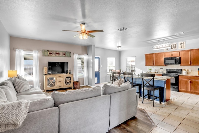 1380 Levi Ln, Forney, TX 75126 - living room featuring a wealth of natural light, visible vents, ceiling fan, and light tile patterned floors