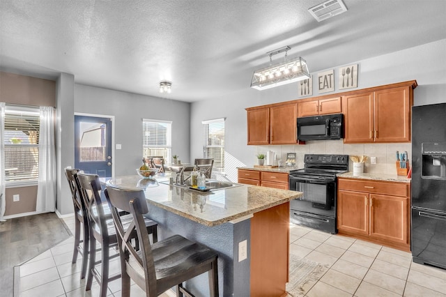 1380 Levi Ln, Forney, TX 75126 - kitchen featuring light tile patterned floors, visible vents, black appliances, and a sink