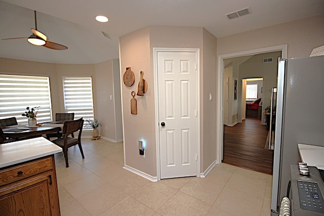510 Canary Ln, Red Oak, TX 75154 - kitchen featuring ceiling fan, freestanding refrigerator, brown cabinets, baseboards, and light tile patterned flooring