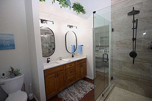 510 Canary Ln, Red Oak, TX 75154 - full bathroom with toilet, a shower stall, double vanity, baseboards, and wood finished floors