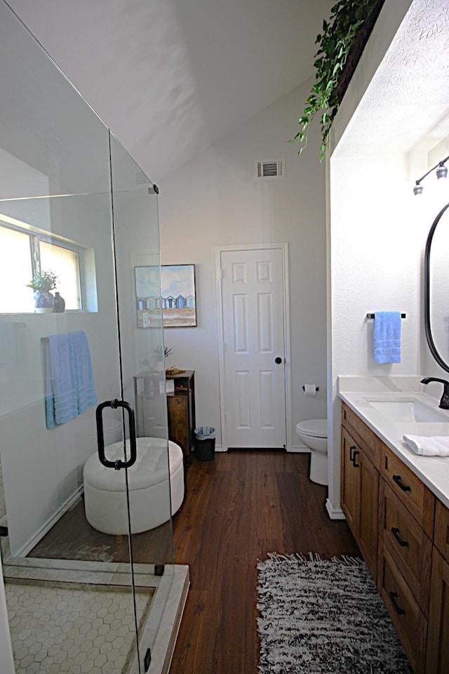510 Canary Ln, Red Oak, TX 75154 - full bathroom with wood finished floors, vaulted ceiling, vanity, a shower stall, and toilet