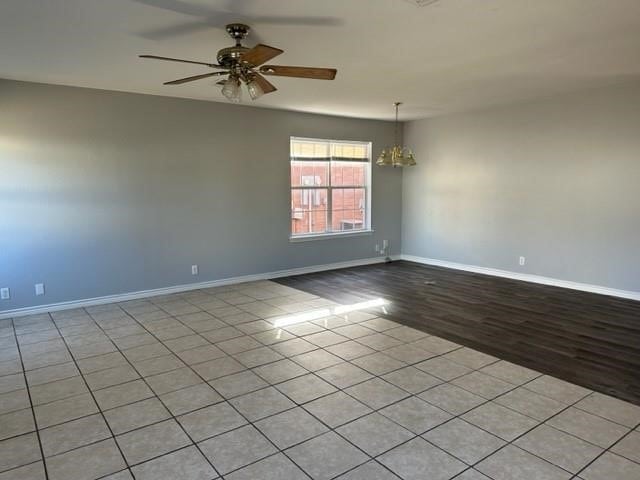 112-114 S Holly Ave, Sherman, TX 75092 - empty room featuring ceiling fan with notable chandelier, light wood-type flooring, and baseboards