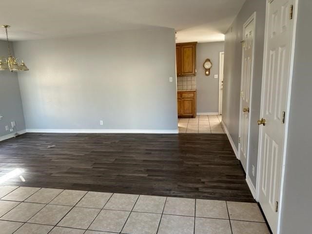 112-114 S Holly Ave, Sherman, TX 75092 - empty room featuring a chandelier, baseboards, and light tile patterned flooring