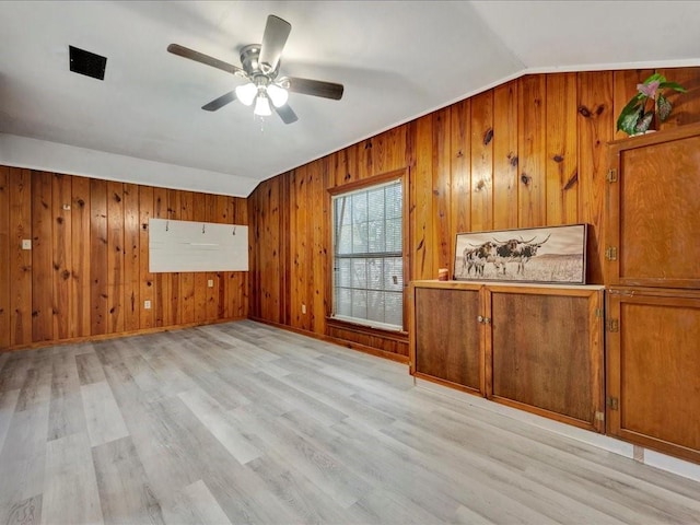 1402 Murphy Ave, Lufkin, TX 75904 - unfurnished room with light wood-style flooring, wood walls, ceiling fan, and vaulted ceiling