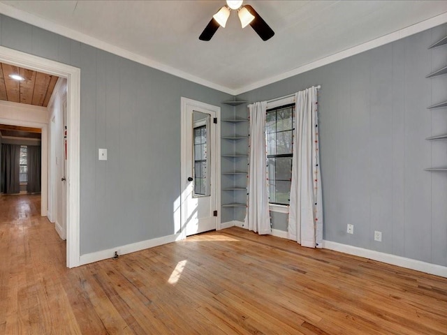 1402 Murphy Ave, Lufkin, TX 75904 - empty room featuring crown molding, a ceiling fan, wood finished floors, built in features, and baseboards
