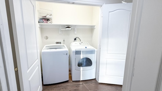 washroom featuring laundry area, separate washer and dryer, and dark wood finished floors