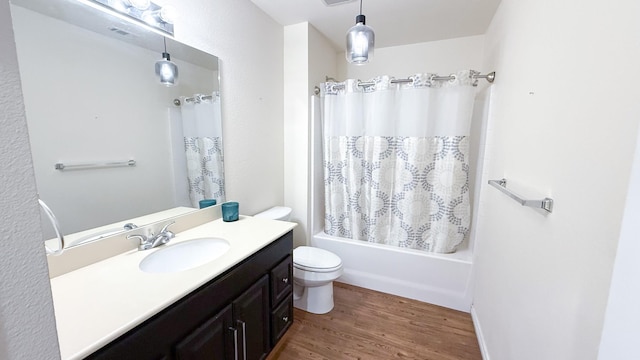 bathroom featuring toilet, wood finished floors, vanity, and shower / bathtub combination with curtain