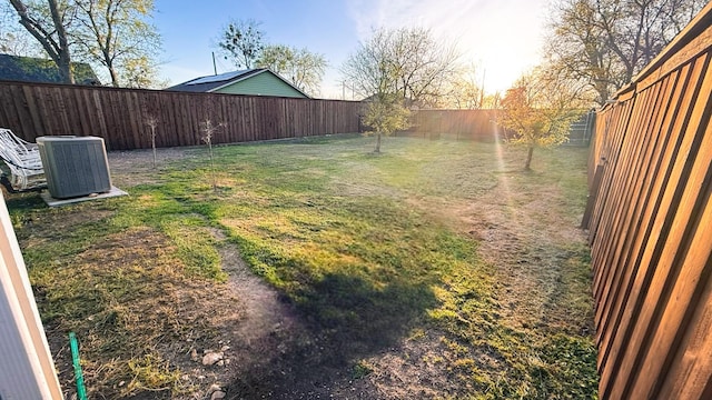 view of yard featuring central AC and a fenced backyard