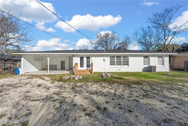 back of property featuring driveway, fence, cooling unit, french doors, and an attached carport