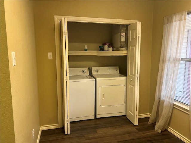clothes washing area featuring baseboards, separate washer and dryer, dark wood-style flooring, and laundry area