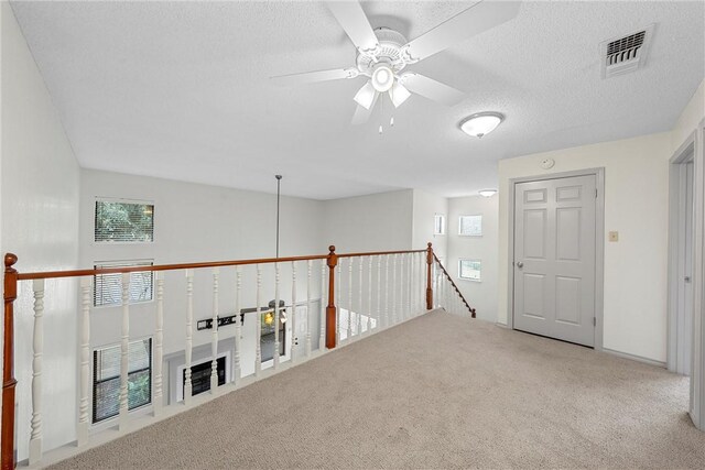 125 Pleasant Grove Ln, Waco, TX 76712 - hallway featuring visible vents, carpet floors, a textured ceiling, and an upstairs landing