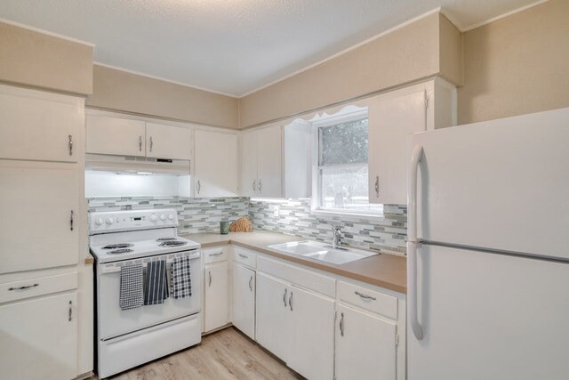 102 E Robertson Ave, Copperas Cove, TX 76522 - kitchen featuring under cabinet range hood, tasteful backsplash, a sink, and white appliances