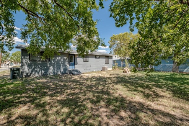102 E Robertson Ave, Copperas Cove, TX 76522 - rear view of property with entry steps, a lawn, and fence