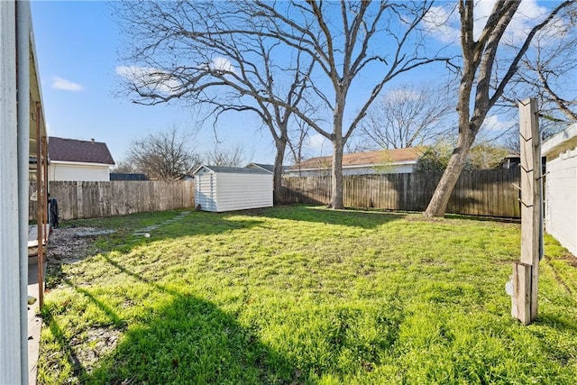 view of yard with an outdoor structure, a storage unit, and a fenced backyard