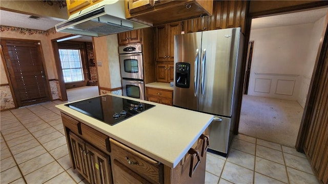 kitchen with light tile patterned flooring, stainless steel appliances, light countertops, under cabinet range hood, and light colored carpet