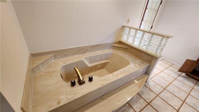 bathroom with tile patterned flooring and a jetted tub