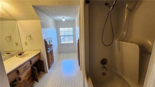 bathroom featuring tile patterned floors, a textured ceiling,  shower combination, baseboards, and vanity
