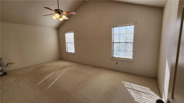 carpeted empty room featuring high vaulted ceiling, a textured ceiling, and a ceiling fan