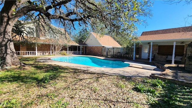 view of pool with a patio, fence, a diving board, a fenced in pool, and ceiling fan