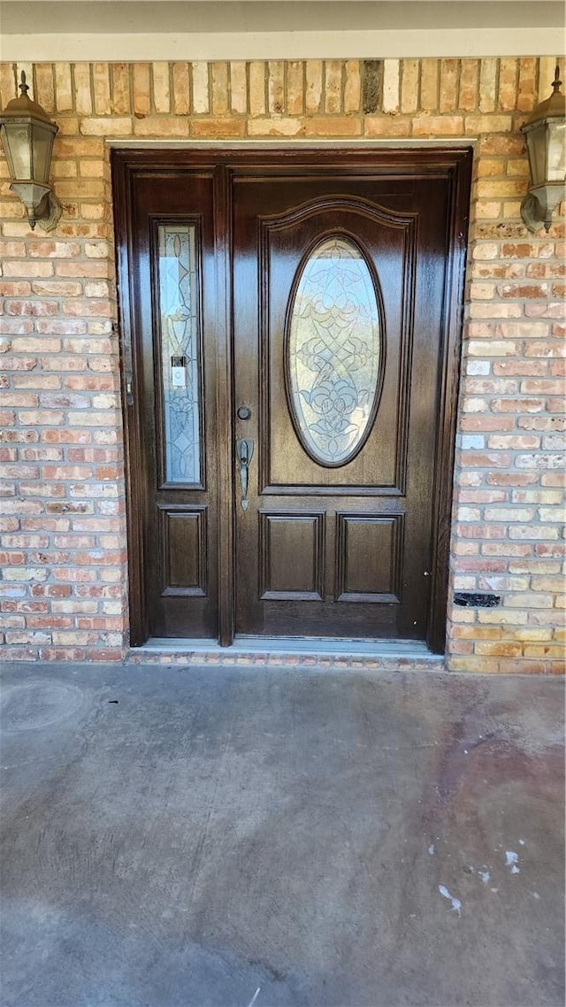 doorway to property with brick siding