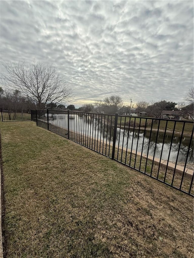 view of yard featuring a water view and fence