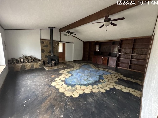 unfurnished living room featuring a wood stove, a textured ceiling, ceiling fan, and vaulted ceiling with beams