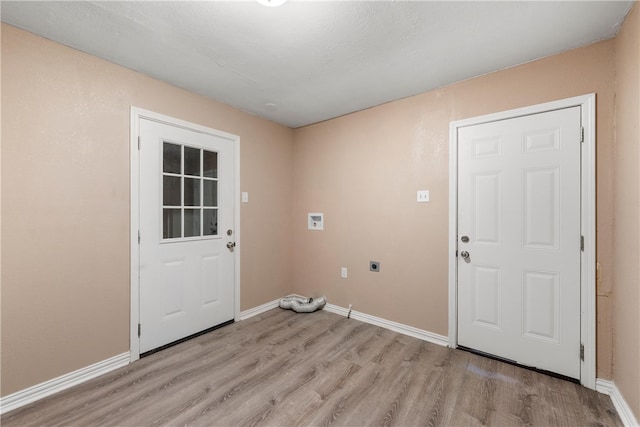 laundry area featuring light wood finished floors, laundry area, hookup for an electric dryer, and baseboards