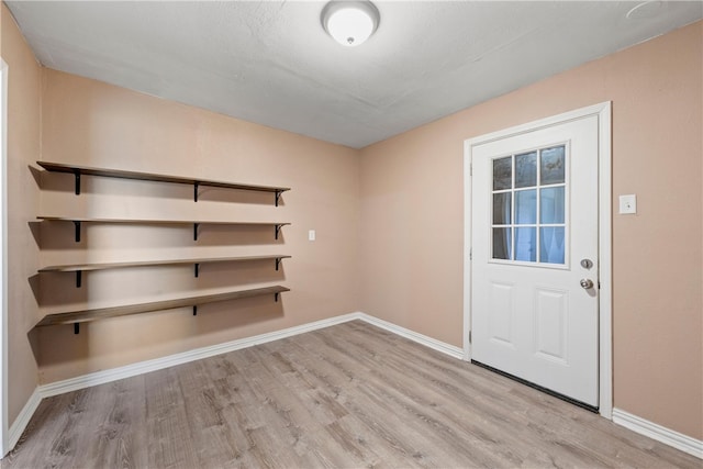 interior space with baseboards and wood finished floors