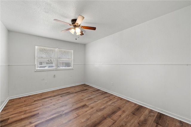 unfurnished room with baseboards, wood finished floors, a textured ceiling, and ceiling fan