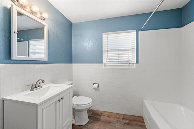 bathroom featuring toilet, wood finished floors, tub / shower combination, and a wealth of natural light