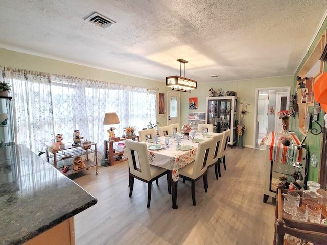 3833 Huaco Ln, Waco, TX 76710 - dining room with a textured ceiling and light wood finished floors