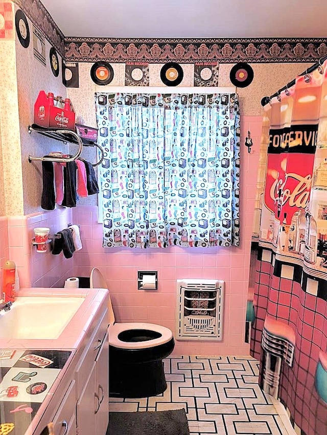 3833 Huaco Ln, Waco, TX 76710 - full bathroom with tile walls, heating unit, toilet, vanity, and a shower with curtain
