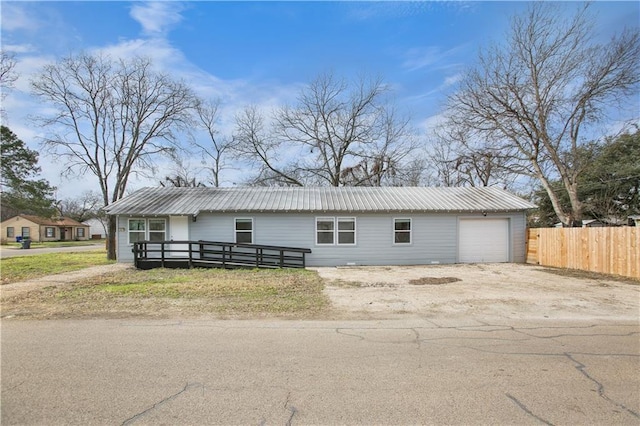 3801 Cumberland Ave, Waco, TX 76707 - ranch-style house with metal roof, a garage, dirt driveway, and fence