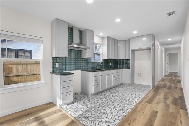3801 Cumberland Ave, Waco, TX 76707 - kitchen featuring visible vents, backsplash, wall chimney range hood, and a sink
