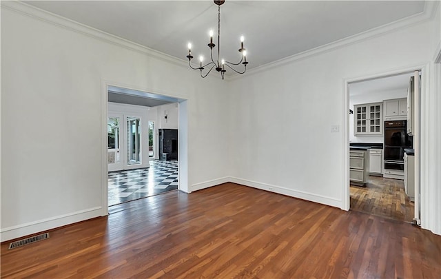 3720 Herwol Ave, Waco, TX 76710 - spare room featuring visible vents, dark wood finished floors, an inviting chandelier, crown molding, and baseboards