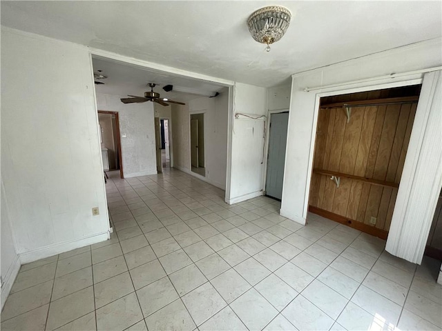 interior space with a ceiling fan and baseboards