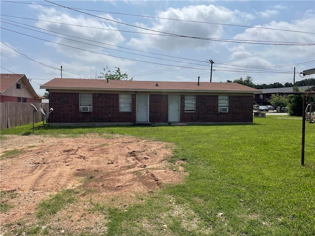 ranch-style home with a front lawn, cooling unit, fence, and brick siding