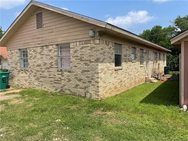 view of home's exterior with a yard and brick siding