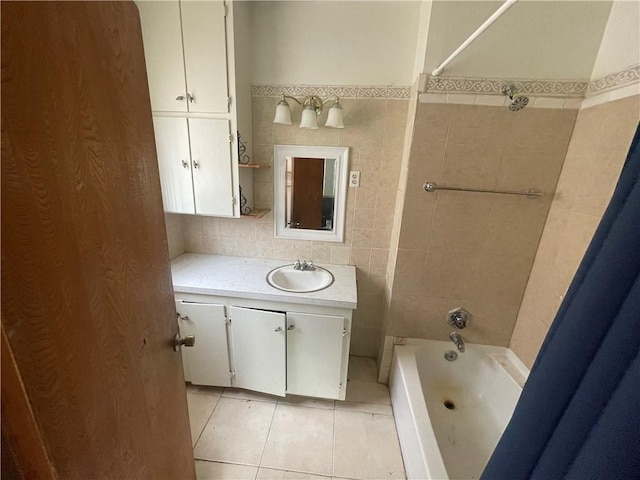 full bathroom with tile patterned floors, shower / bath combination, tile walls, and vanity