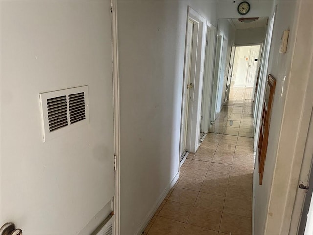 hallway featuring light tile patterned floors and visible vents